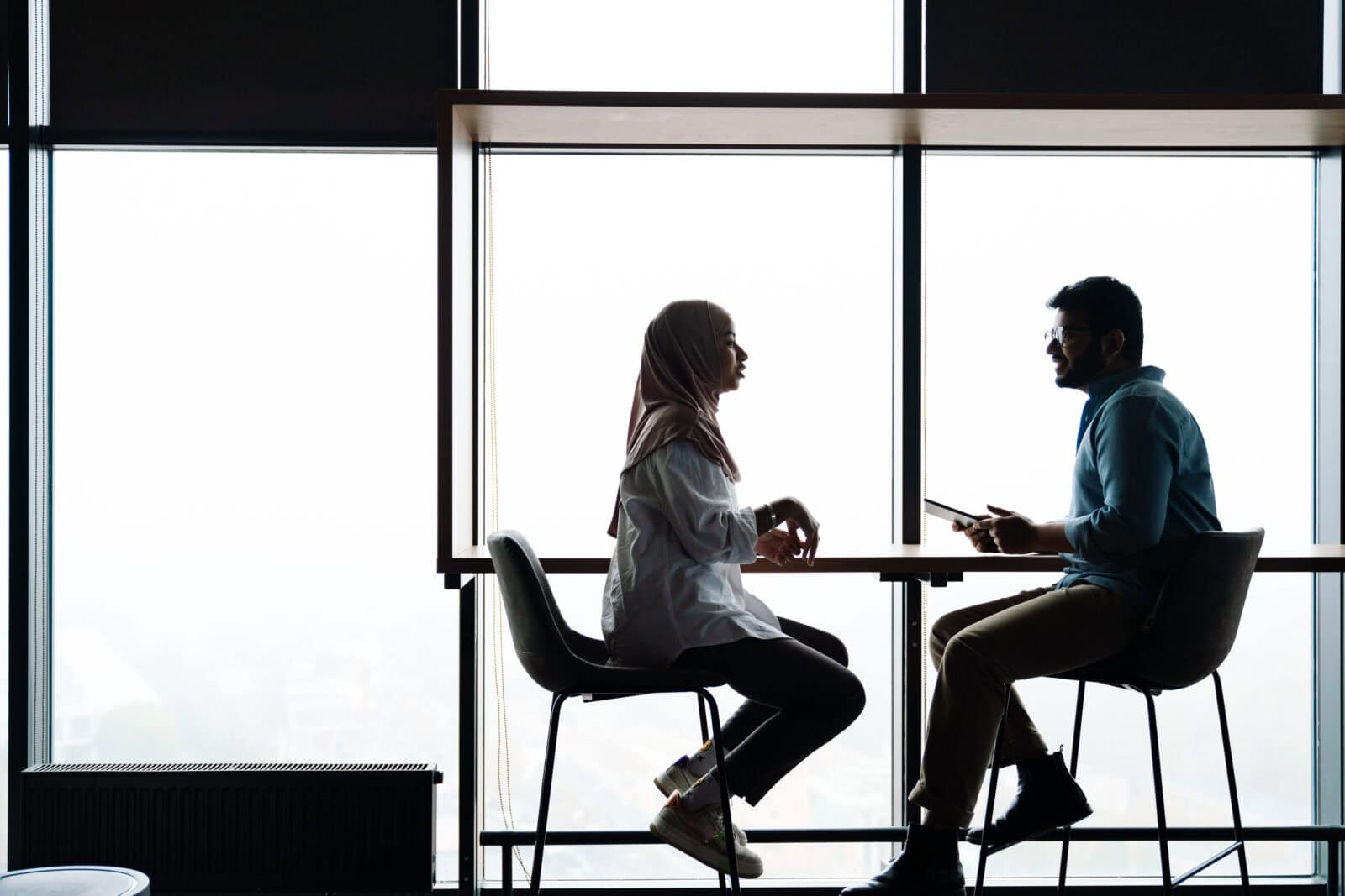Two Coworkers Discussing Project During Business Meeting In Office